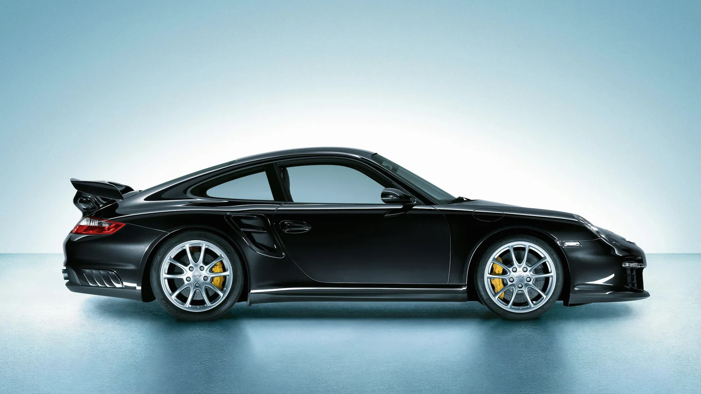 Black Porsche 997 GT2 in side profile, showing its fixed wing and side intake