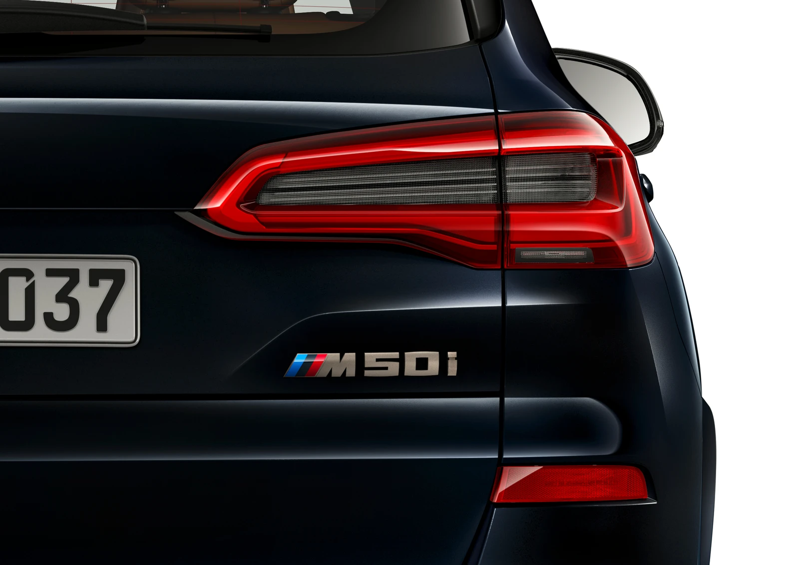 Close rear view of a dark BMW X5 M50i, showing the M50i tailgate badge and right tail lamp.